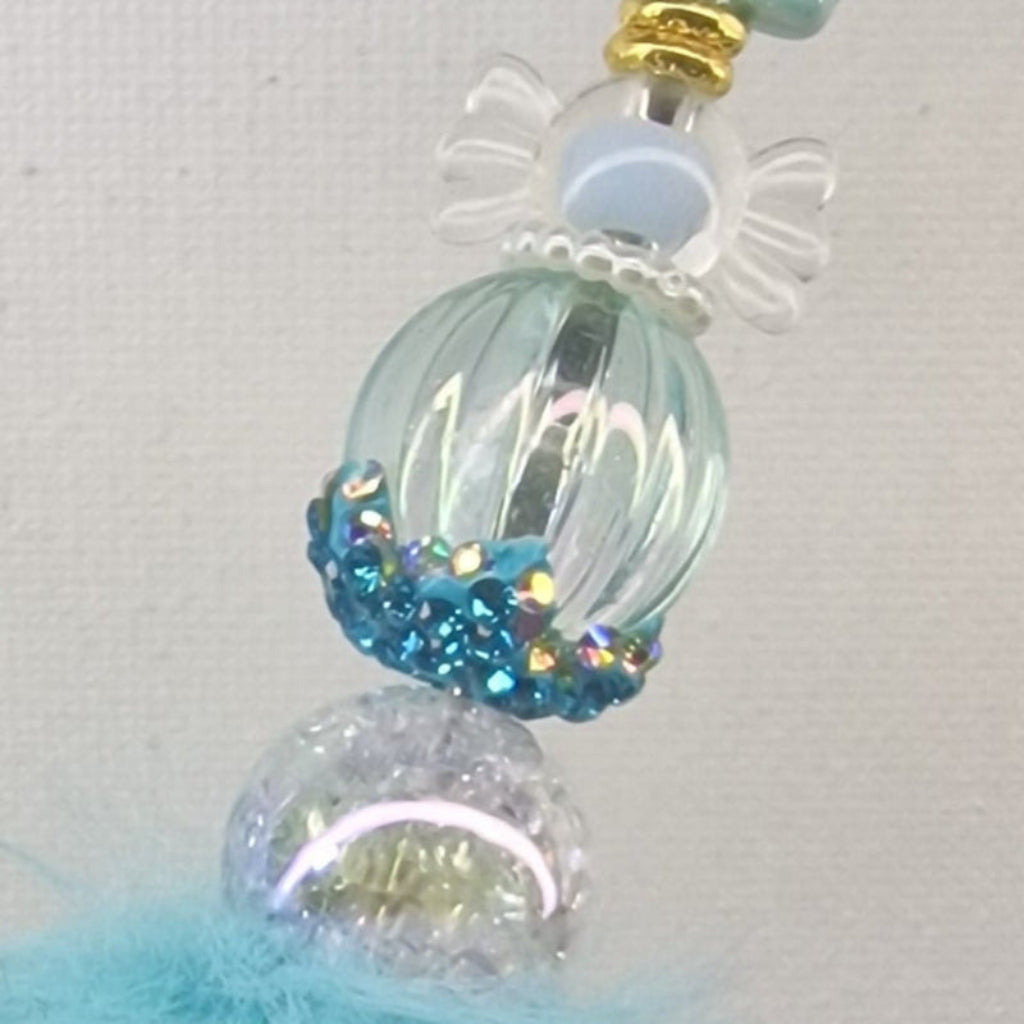 Handversierde turquoise fluffy pen met ondeugend poppetje en blauwe strass kralen – detailfoto