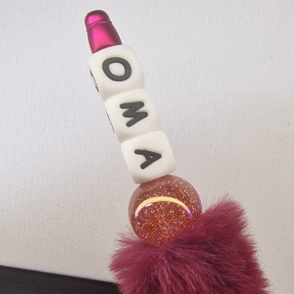Handversierde rode fluffy pen met witte letterkubussen 'oma' en glanzende kraal – detailfoto
