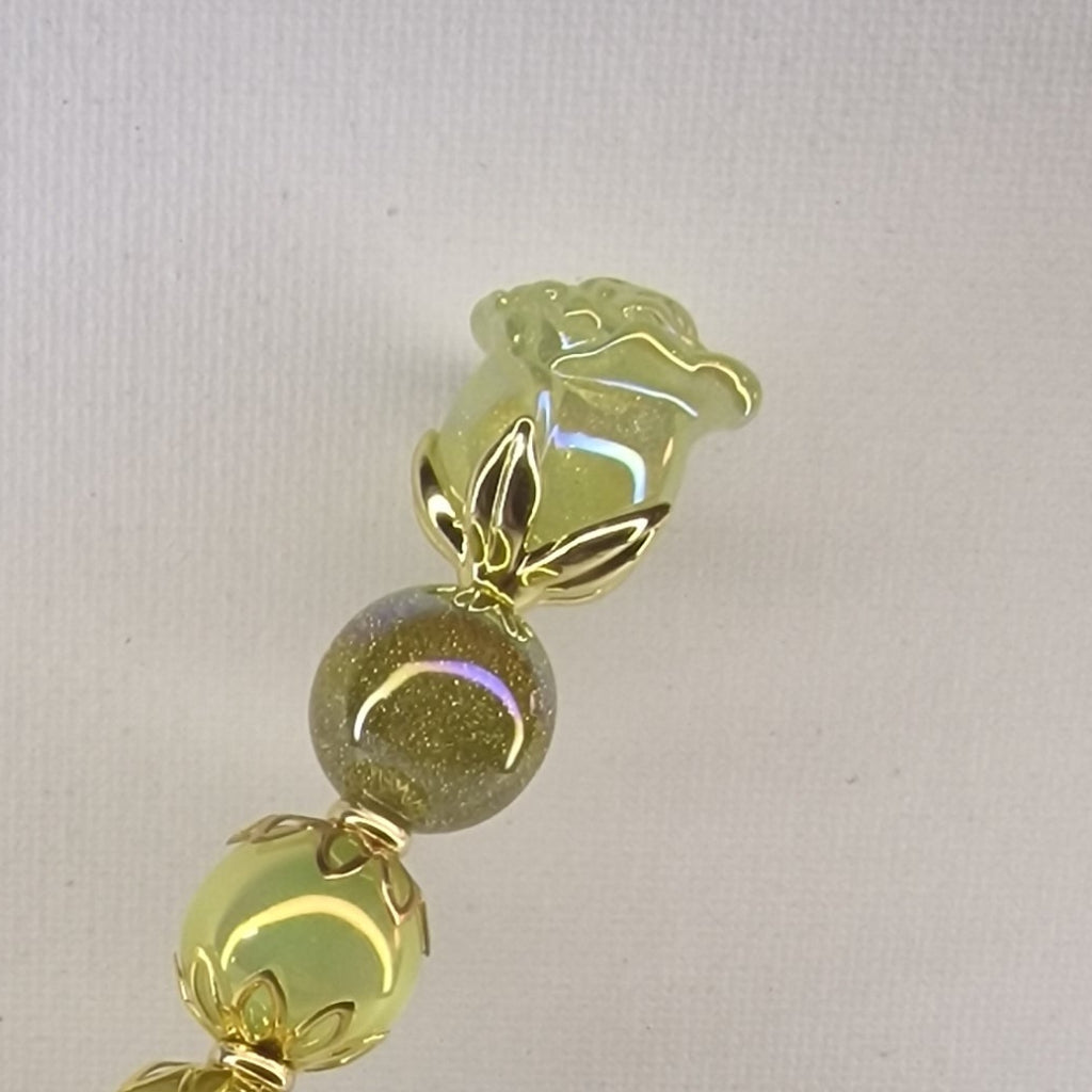 Handversierde gele pen met glanzend roosje en goudkleurige bloemspacers – detailfoto