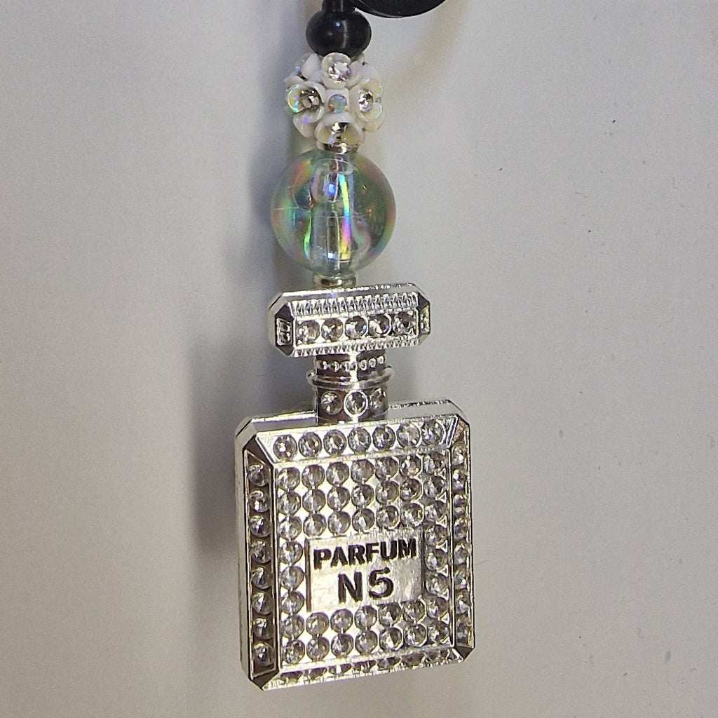 Handversierde zwarte sleutelhanger met zilverkleurig parfumflesje en strass-steentjes – detailfoto