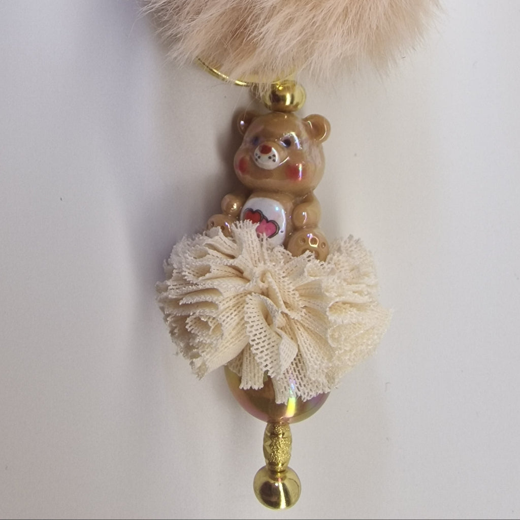 Goudkleurige sleutelhanger met beertje en pompon