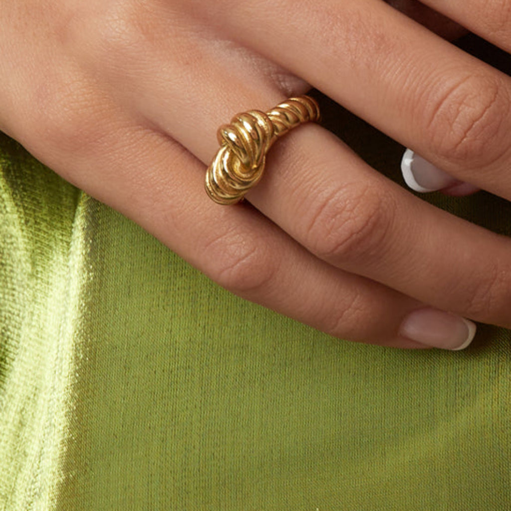 Goudkleurige statement ring met knoop- en streepdetailsdetails