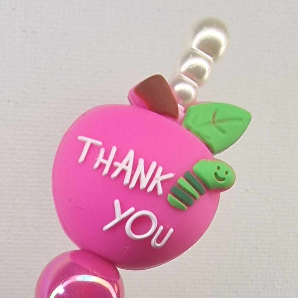 Handversierde goudkleurige pen met fuchsia appel en 'Thank you Teacher' – detailfoto
