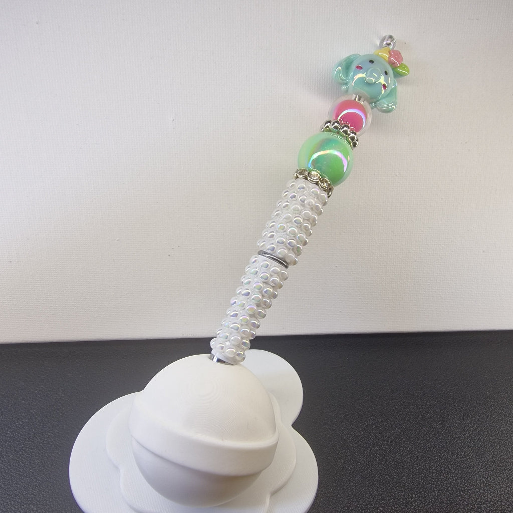 Handversierde witte parelmoer pen met olifantje en roze en groene kralen
