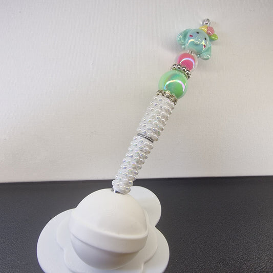 Handversierde witte parelmoer pen met olifantje en roze en groene kralen
