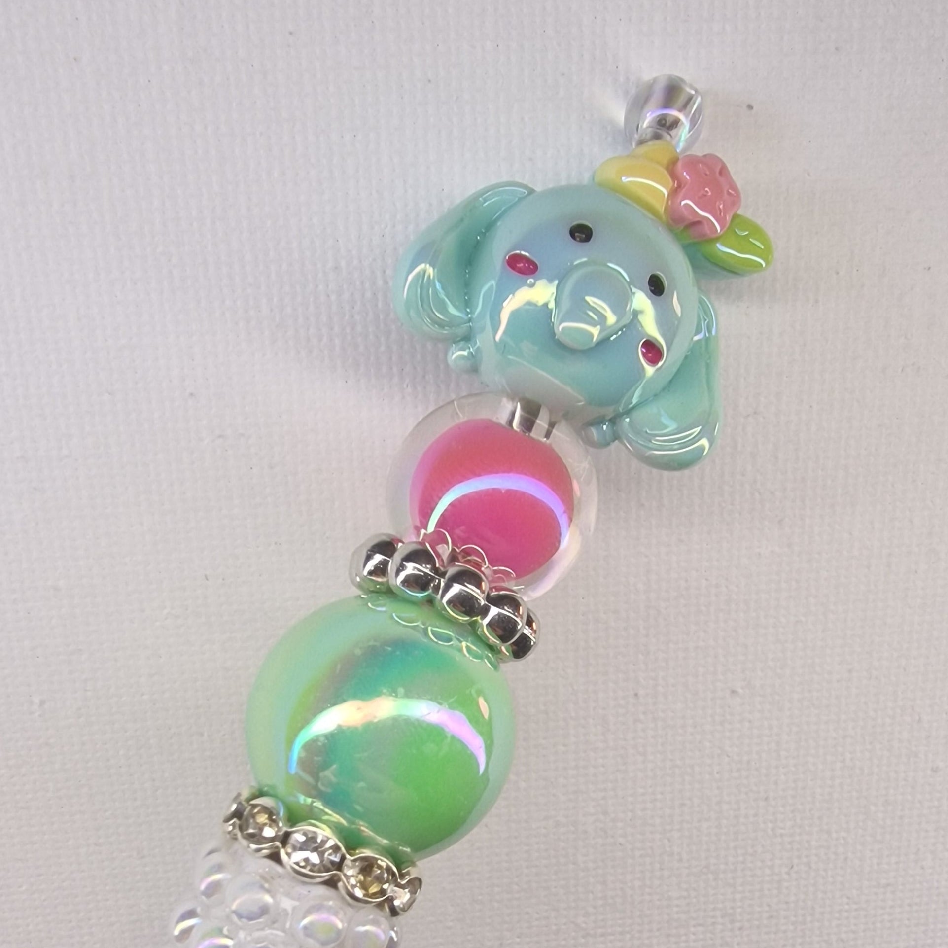 Handversierde witte parelmoer pen met olifantje en roze en groene kralen – detailfoto
