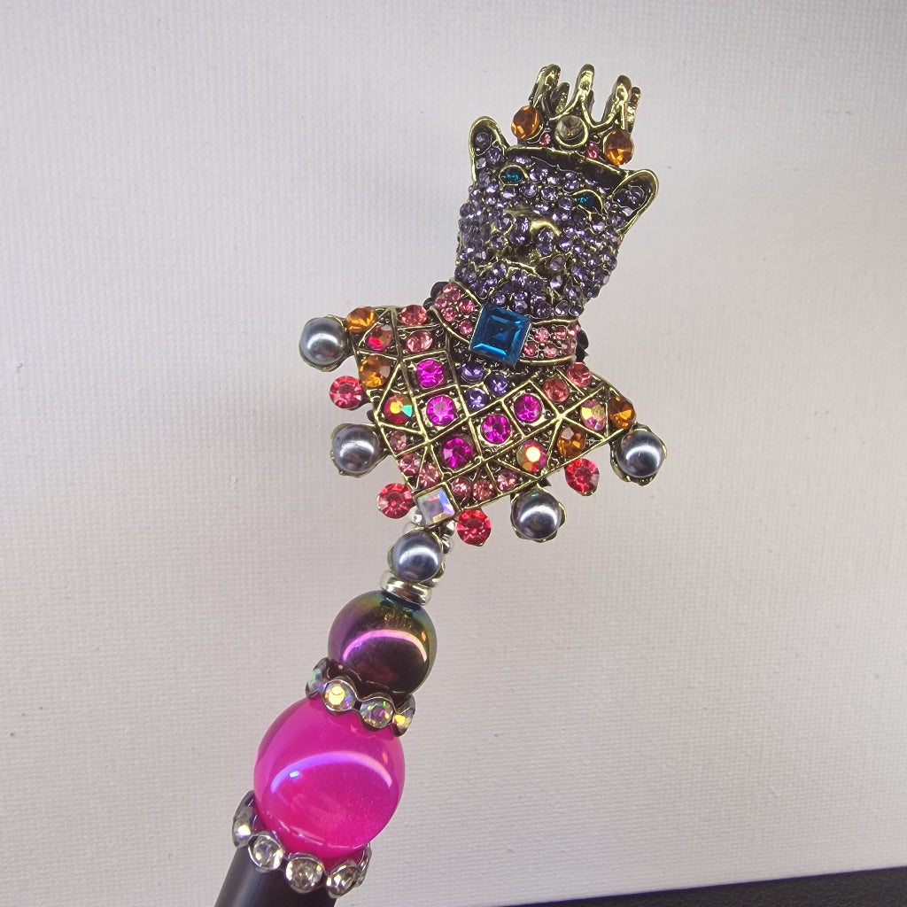 Handversierde zwarte pen met kleurrijke beer en kroon bezet met strass – detailfoto
