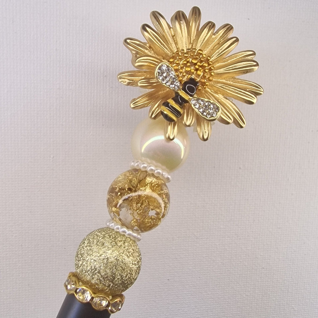 Handversierde zwarte pen met honingbijtje op madeliefje en strass vleugels – detailfoto
