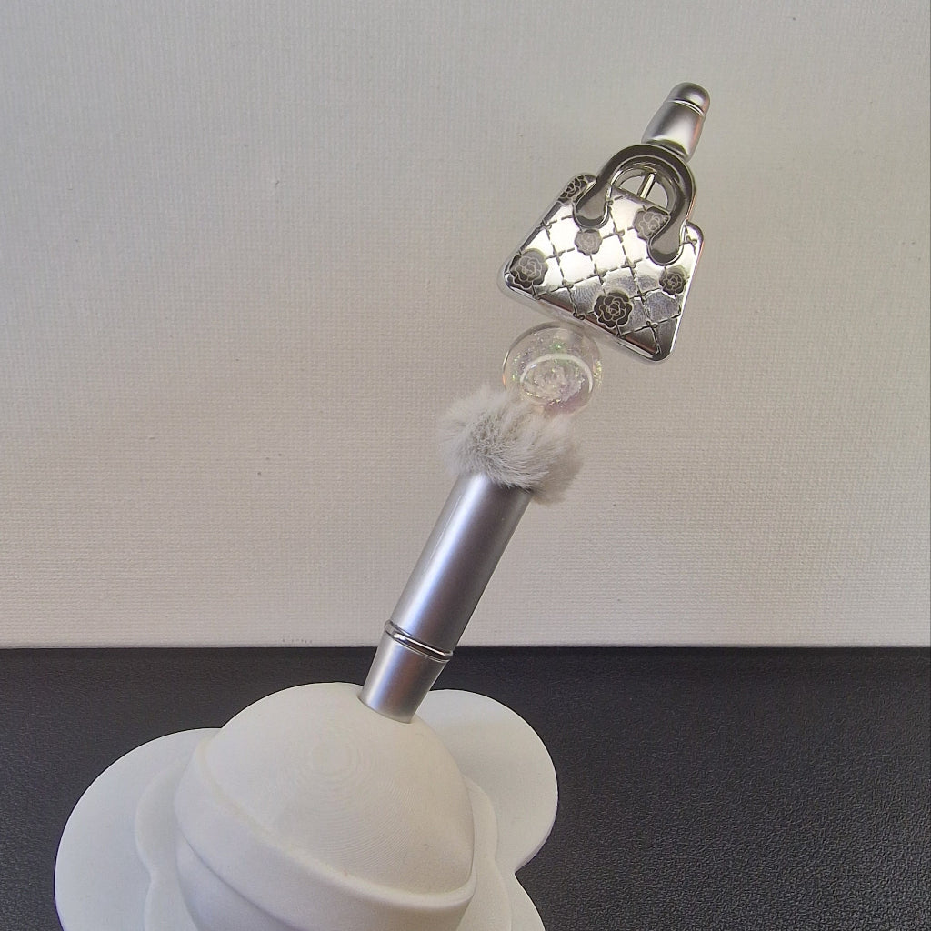 Handversierde zilveren pen met nepbont en zilveren handtasje met bloemetjes
