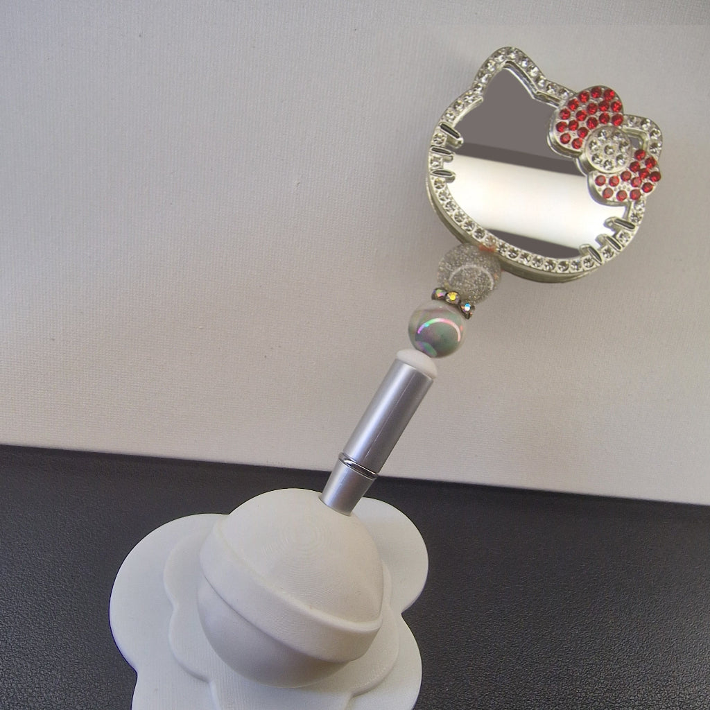 Handversierde zilverkleurige pen met kattenvormige spiegel en rood rhinestone strikje
