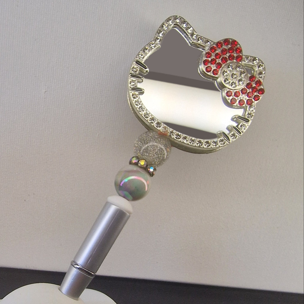 Handversierde zilverkleurige pen met kattenvormige spiegel en rood rhinestone strikje – detailfoto
