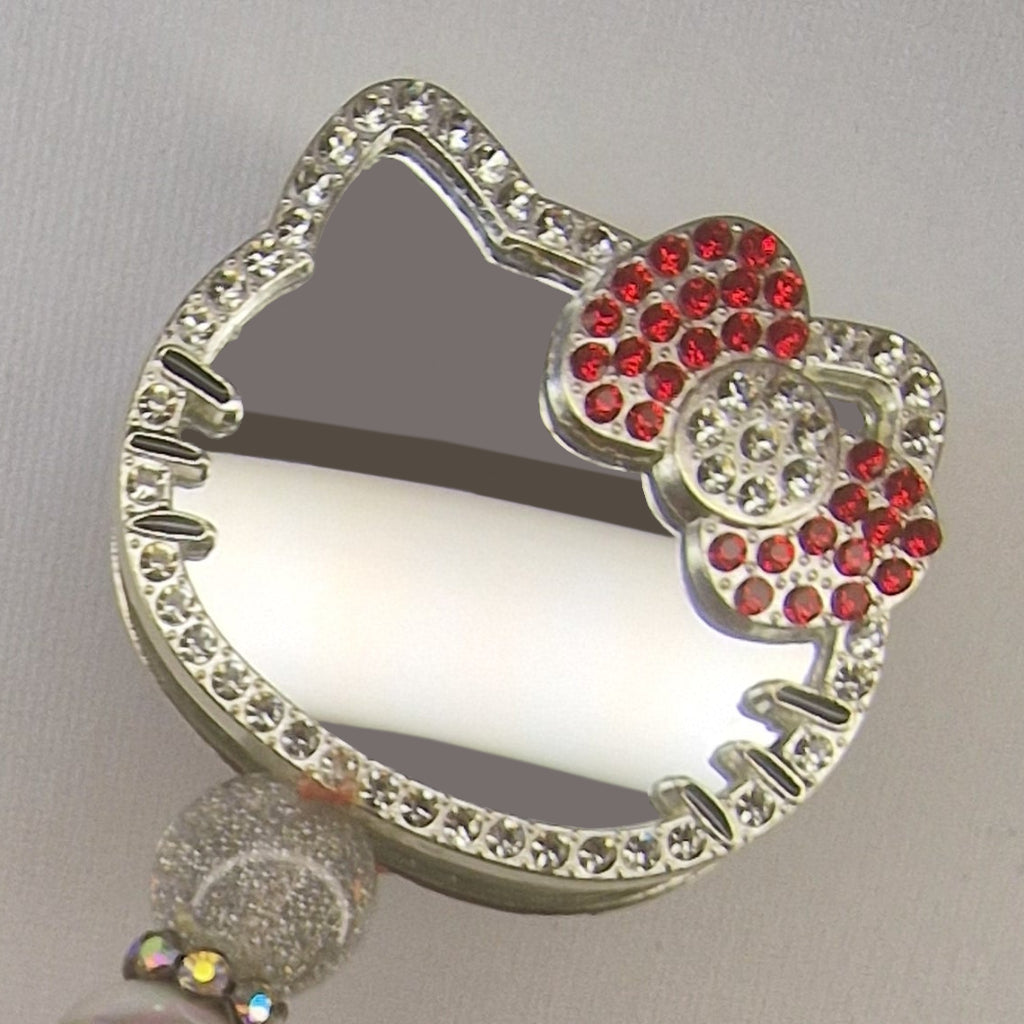 Handversierde zilverkleurige pen met kattenvormige spiegel en rood rhinestone strikje – detailfoto
