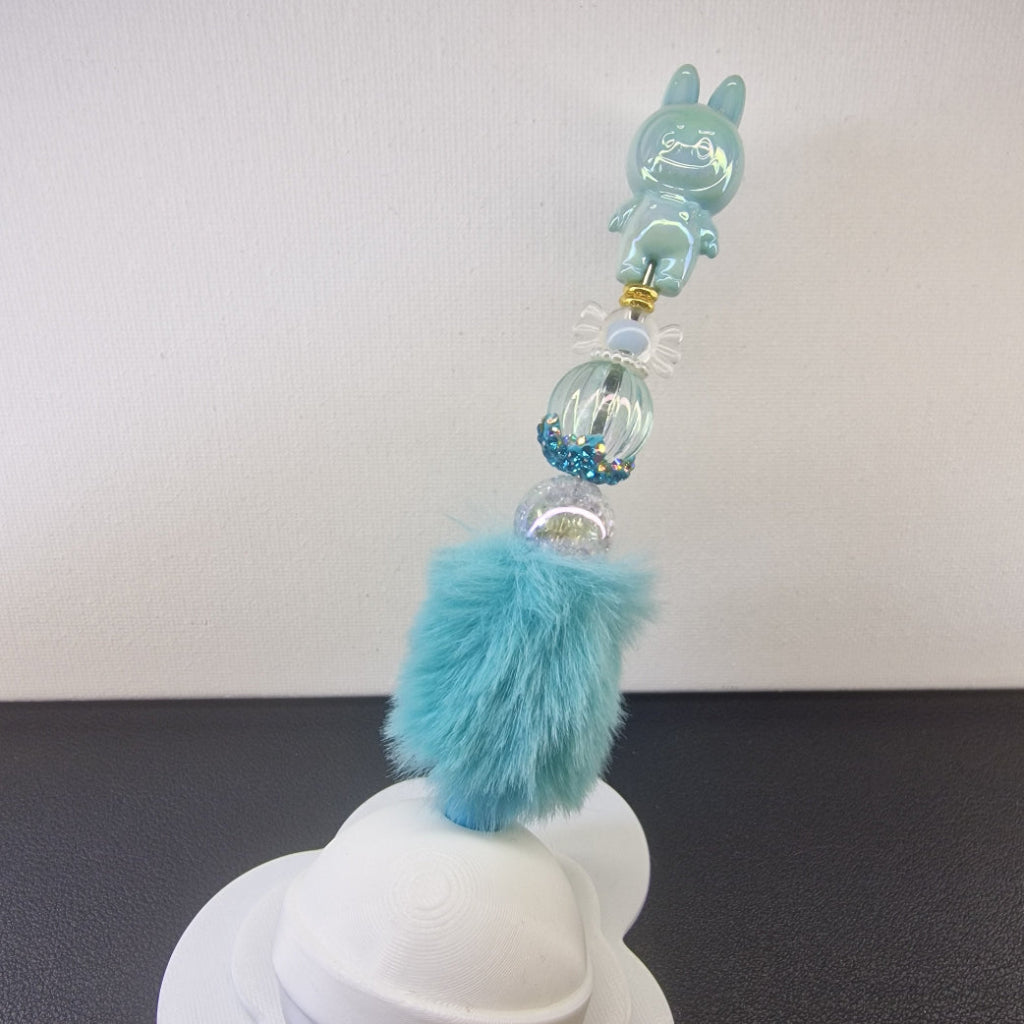 Handversierde turquoise fluffy pen met ondeugend poppetje en blauwe strass kralen
