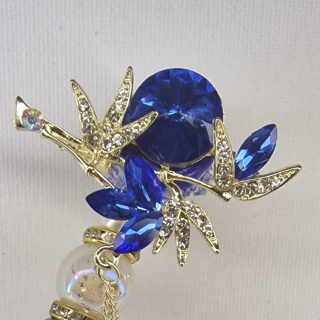 Handversierde goudkleurige pen met bloemtop en Perzisch blauwe strass-steentjes – detailfoto