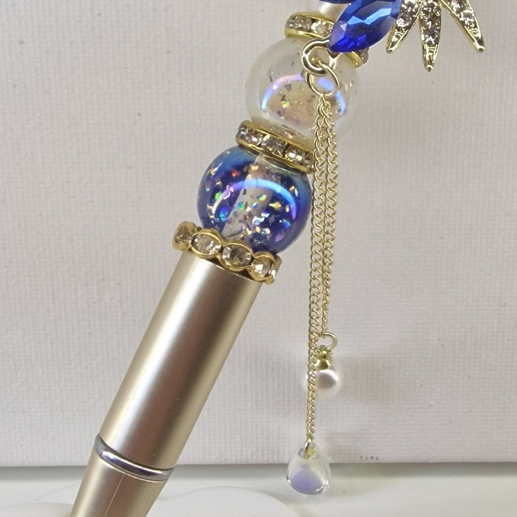 Handversierde goudkleurige pen met bloemtop en Perzisch blauwe strass-steentjes – detailfoto