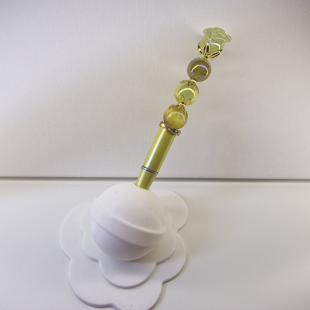 Handversierde gele pen met glanzend roosje en goudkleurige bloemspacers
