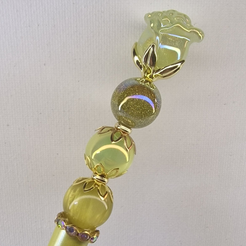 Handversierde gele pen met glanzend roosje en goudkleurige bloemspacers – detailfoto
