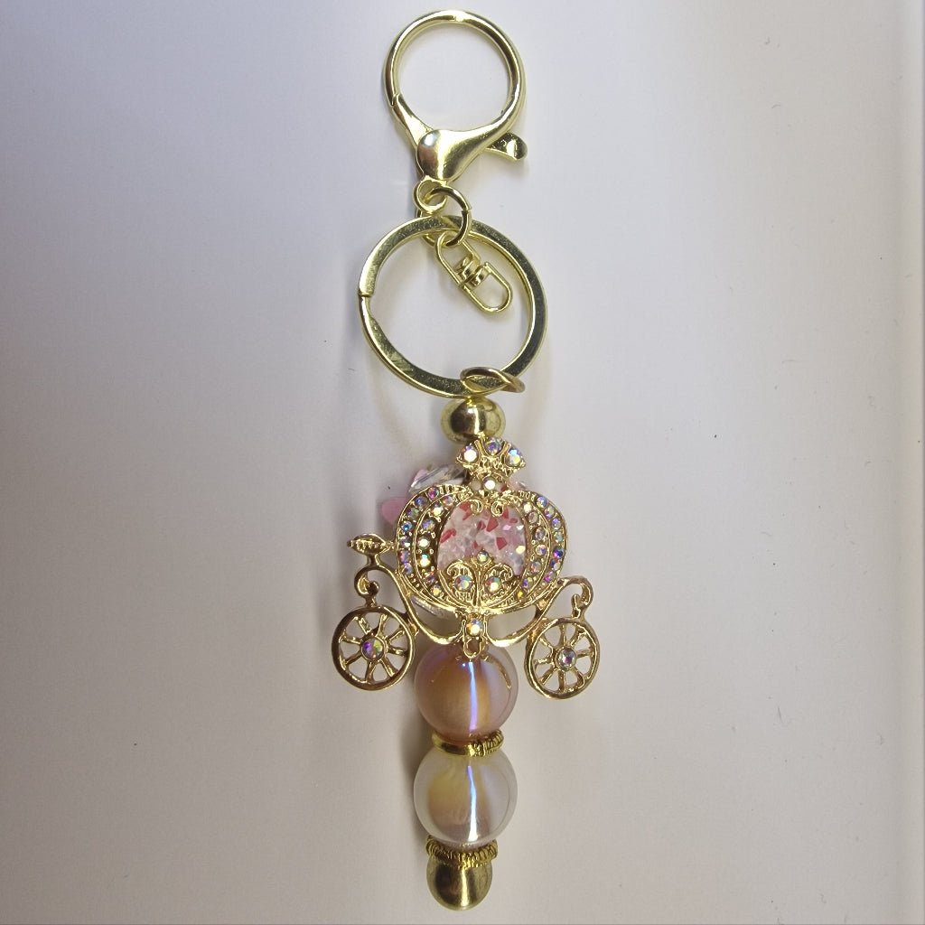 Handversierde goudkleurige sleutelhanger met koets en strass-steentjes