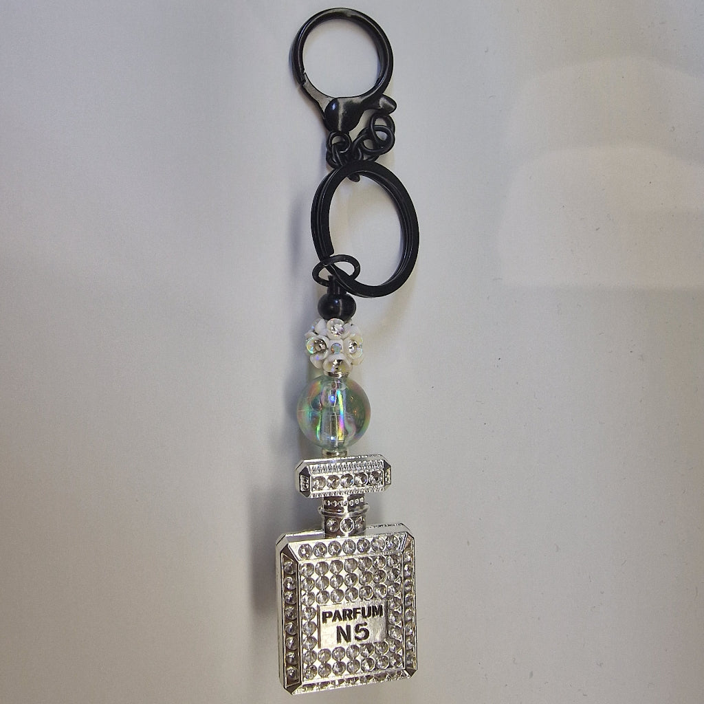 Handversierde zwarte sleutelhanger met zilverkleurig parfumflesje en strass-steentjes – vooraanzicht

