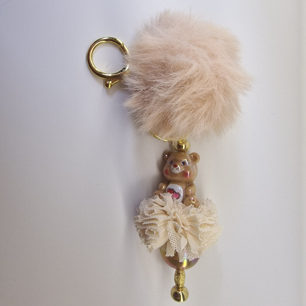 Goudkleurige sleutelhanger met beertje en pompon