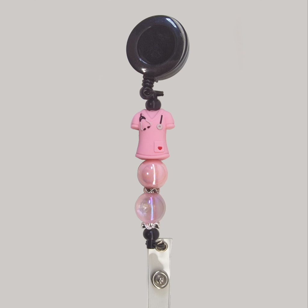 Handversierde zwarte badgehouder met roze verpleeguniform en warmroze kralen
