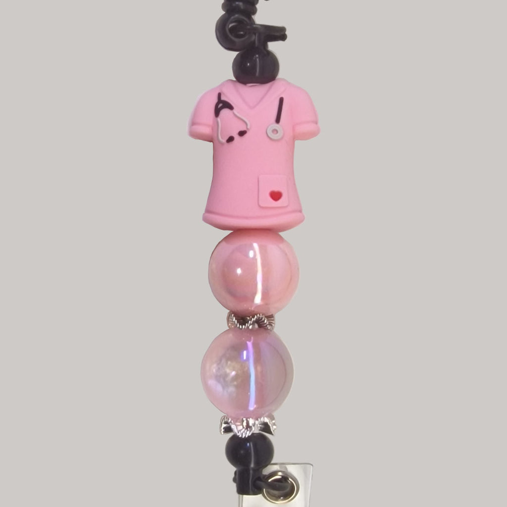 Handversierde zwarte badgehouder met roze verpleeguniform en warmroze kralen – detailfoto
